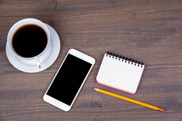 Vista dall'alto della tazza di caffè con smart phone su sfondo in legno — Foto Stock