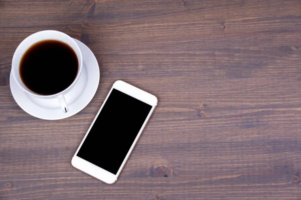 Vista dall'alto della tazza di caffè con smart phone su sfondo in legno — Foto Stock