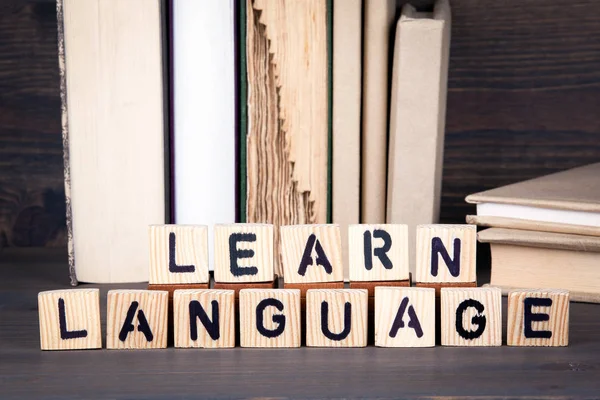 Aprender el idioma, letras de madera en la mesa de madera. Educación, éxito y comunicación —  Fotos de Stock