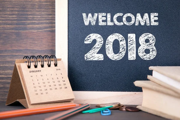 Welcome 2018. paper calendar and chalkboard on a wooden table — Stock Photo, Image