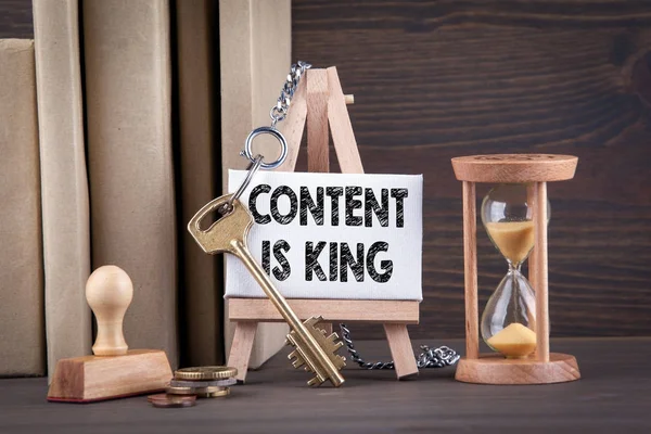 content is king concept. Sandglass, hourglass or egg timer on wooden table
