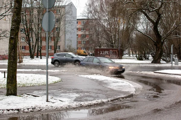 Lettland, Riga - 1. Dezember 2017: nasser Schnee in der Stadt, Verkehr und Menschen auf den glatten Straßen — Stockfoto