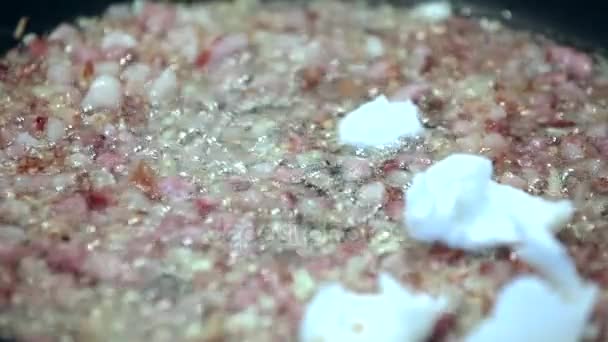 Faire la nourriture du dîner, couper l'oignon avec la cuisson de la viande sur la poêle, ajouter de la graisse, des bulles d'huile 