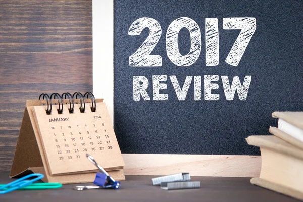 Revisión 2017. calendario de papel y pizarra sobre una mesa de madera —  Fotos de Stock