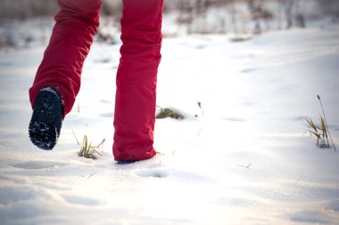 Dondurucu kışın kar kırmızı pantolon ve kar üzerinde yürüme bot