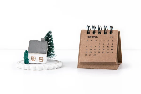 Kleine huis model en boom op witte achtergrond met agenda 2018 en de maand februari — Stockfoto