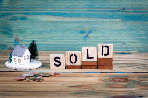 Miniatuur model van huis en houten letter tekst: verkocht — Stockfoto