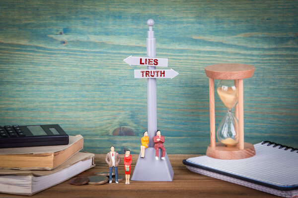 Lies and truth. Signpost on wooden table