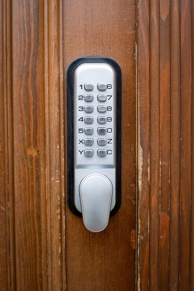 Silver color code key on brown wooden door — Stock Photo, Image