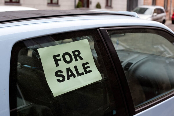 for sale. old dirty car on the street with inscription in the window