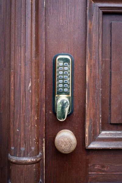 Gold color code key on brown wooden door — Stock Photo, Image