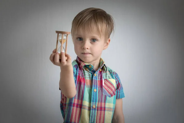 Liten pojke med en sand klocka i handen — Stockfoto