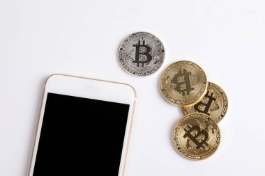 Kripto para birimi, altın bitcoin ve beyaz arka plan üstünde hareket eden telefon