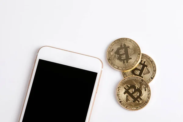 Krypto valuta, gyllene bitcoin och mobiltelefon på vit bakgrund — Stockfoto