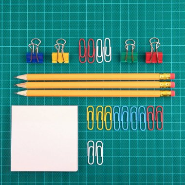 Ofis malzemeleri ve Kırtasiye yeşil kesme tahtası üzerinde