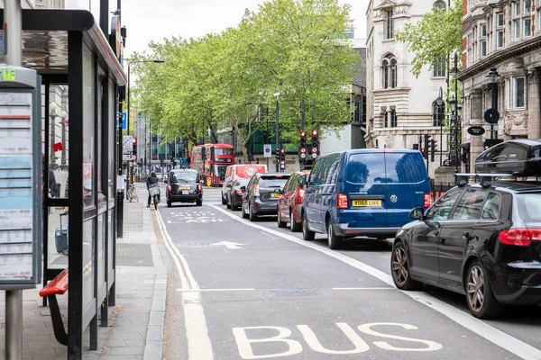Londra sokaklarında kırmızı otobüs ve arabalar, şehir trafik sistemi. Otobüs şeridi