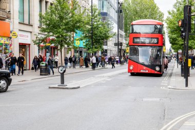 Oxford caddesindeki insanlar Uk 'un en büyük alışveriş caddesi. 73 numaralı kırmızı otobüs.