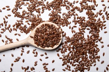 Keten tohumları ve beyaz arka planda bir kaşık