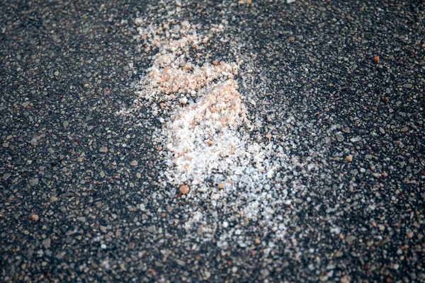 Salt spilled on the pavement. Winter season