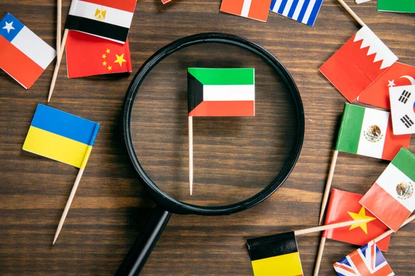 Кувейтський прапор. Прапори багатьох країн, збільшуючи скло на столі — стокове фото