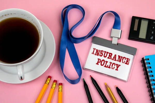 INSURANCE POLICY. Staff Identity, black calculator and a cup of coffee on a pink background