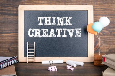 Yaratıcı düşün. Tebeşir tahtası, kitaplar, balonlar ve ofis malzemeleri.