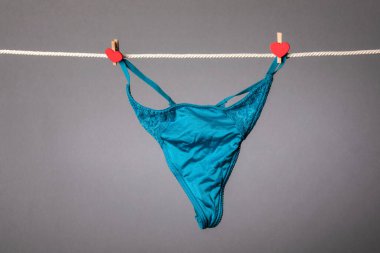 Çamaşır ipinde kadın külotu ve kırmızı ısıtmalı mandallar.