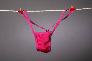 Kırmızı kadın külotları çamaşır ipinde, askıları kırmızı ısıtmalı.