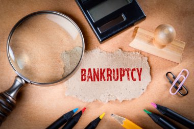 BANKRUPTCY konsepti. Büyüteç, kırtasiye ve not kağıdı.