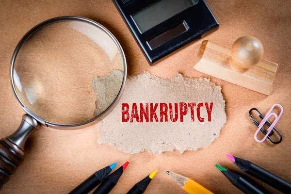 BANKRUPTCY έννοια. Μεγεθυντικό γυαλί, γραφική ύλη και χαρτί σημειώσεων — Φωτογραφία Αρχείου