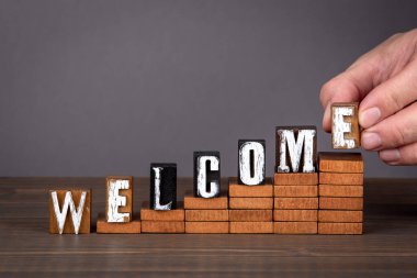 Hoş geldin konsepti. Adımlarda tahta alfabe harfleri