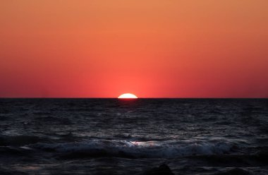 Hazar Denizi'nin vahşi sahil şeridi üzerinde günbatımı