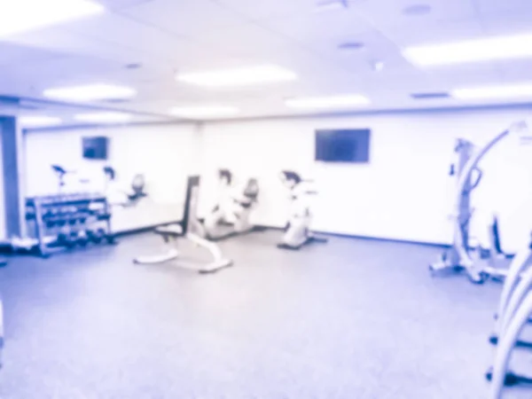 Verschwommener Hintergrund Hantelständer und Trainingsgeräte im modernen Fitnesscenter in den USA — Stockfoto