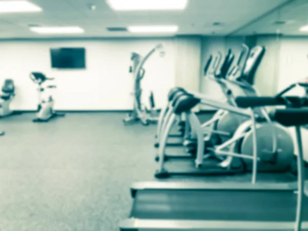 Rozmazané pozadí běžecký pás, eliptické, chodec a cvičení zařízení v moderním fitness centru v USA — Stock fotografie