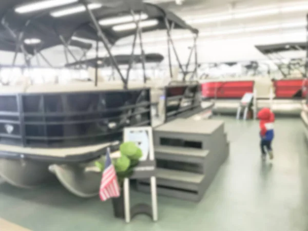 Blurry background Asian boy showing boat at large indoor showroom in America — Stock Photo, Image