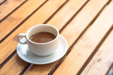 Geleneksel sıcak Vietnam sütlü kahvesi seramik fincan ve çay tabağında.