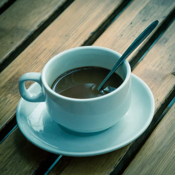 ろ過されたイメージスプーンとソーサー付きの白いセラミックカップでベトナムのミルクコーヒー — ストック写真