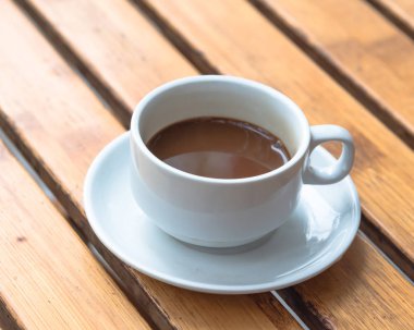 Geleneksel sıcak Vietnam sütlü kahvesi seramik fincan ve çay tabağında.