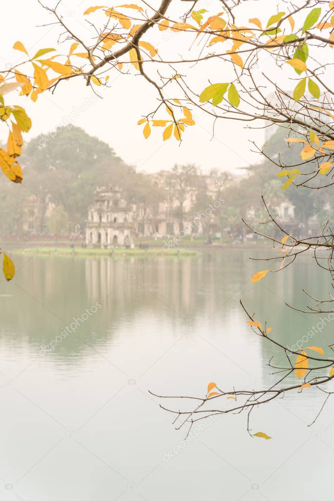 Bright yellow leaves of freshwater mangrove and Tortoise Tower at Hoan Kiem Lake, Hanoi