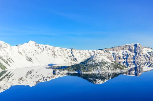 Naturskön vinter spegel reflektion av snowcap berg och trollkarl Island på Crater Lake — Stockfoto