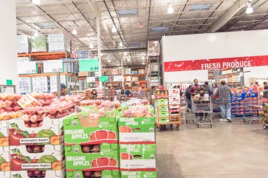 Meşgul insanlar, Kara Cuma 'daki Costco toptan satış mağazasında taze ürünler stokluyor.