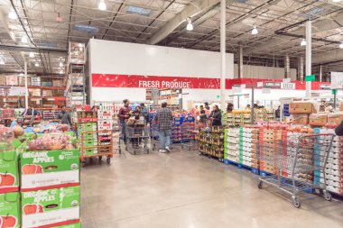 Meşgul insanlar, Kara Cuma 'daki Costco toptan satış mağazasında taze ürünler stokluyor.