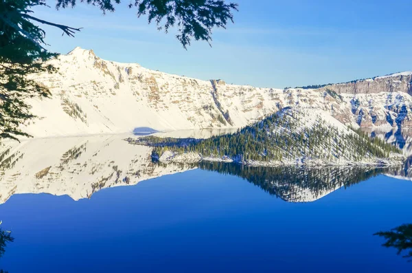 Groene dennenboom weelderig en reflectie van snowcap berg met Wizard Island op Crater Lake — Stockfoto