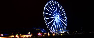 Panoramic night view of Seattle Great Wheel observation at Pier 57 in Seattle, Washington clipart