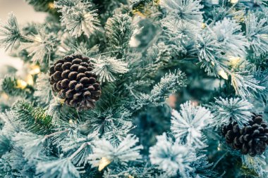 Çam kozalakları ve renkli ışıklar Usa 'daki nalbur dükkanında beyaz yapay Noel ağacına dayandı.