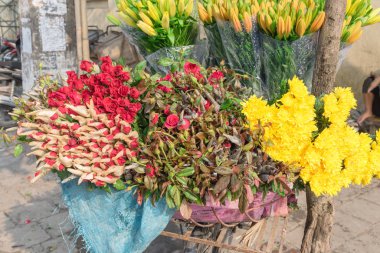 Yakın plan gül, kasımpatı ve nilüfer çiçekleri Hanoi 'de bisiklet sokağı satıcısına yerleştirildi.