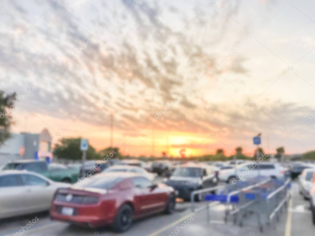 Abstract blurred dramatic sunset cloud at uncovered parking lots near return shopping cart area of grocery store near Dallas, Texas, America.