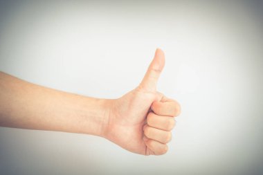 Klasik ton Asyalı erkek eli beyaz arka planda baş parmak işareti gösteriyor. Tam kollu bir jest.