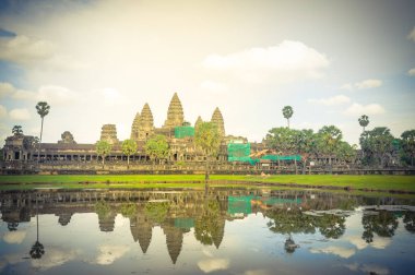 Angkor Wat tapınağı kompleksi yaz bulutları altında göle yansıyor. Kamboçya 'daki antik Khmer mimarisi dünyanın en büyük dini anıtıdır..