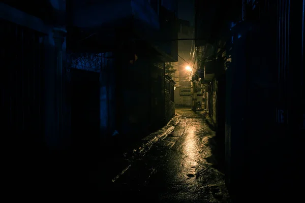 在越南河内郊区 一个漆黑 朦胧和危险的城市小巷 夜晚时分 长路拐角处的邮灯反射在湿路上的微光 — 图库照片